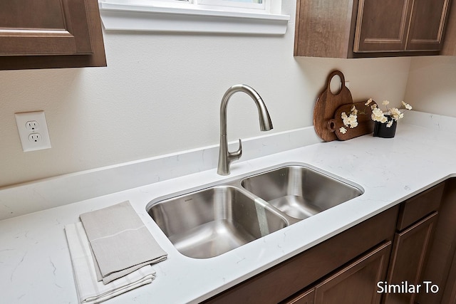 details with dark brown cabinets and a sink