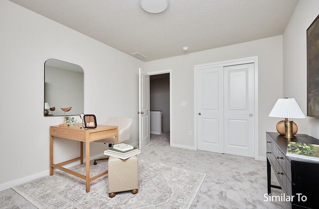 office space featuring baseboards, visible vents, and light colored carpet