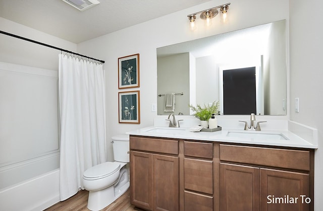 full bathroom with toilet, wood finished floors, a sink, and visible vents
