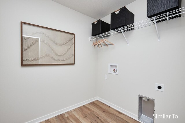 laundry area with baseboards, hookup for a washing machine, wood finished floors, electric dryer hookup, and laundry area