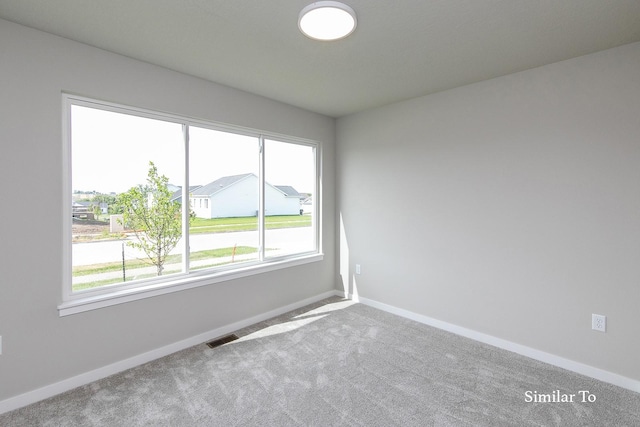 empty room featuring baseboards, a healthy amount of sunlight, and carpet flooring