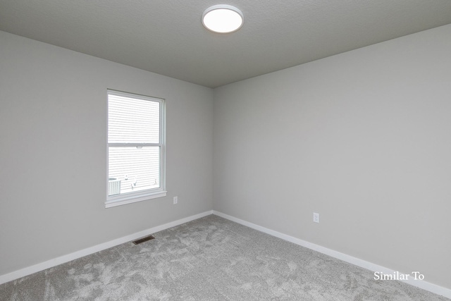 unfurnished room featuring carpet, visible vents, and baseboards