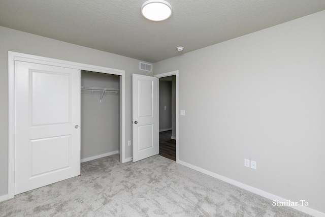 unfurnished bedroom with baseboards, carpet flooring, visible vents, and a closet