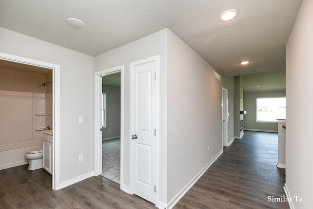 hallway with baseboards, dark wood-style floors, and recessed lighting
