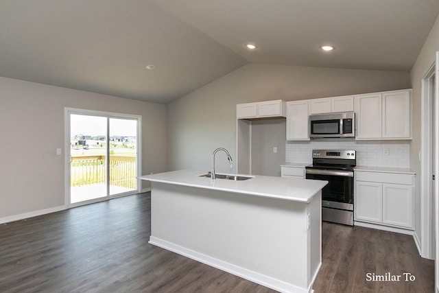 kitchen featuring vaulted ceiling, a sink, decorative backsplash, white cabinetry, and appliances with stainless steel finishes