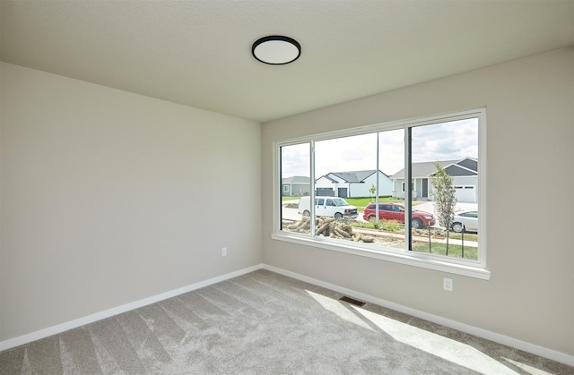 635 NW Compass Ave, Waukee, IA 50263 - carpeted empty room featuring baseboards and a residential view