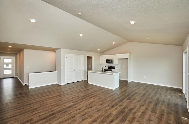 635 NW Compass Ave, Waukee, IA 50263 - unfurnished living room with lofted ceiling, dark wood-style floors, and recessed lighting