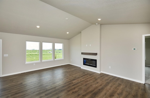 635 NW Compass Ave, Waukee, IA 50263 - unfurnished living room with lofted ceiling, dark wood finished floors, a glass covered fireplace, and recessed lighting