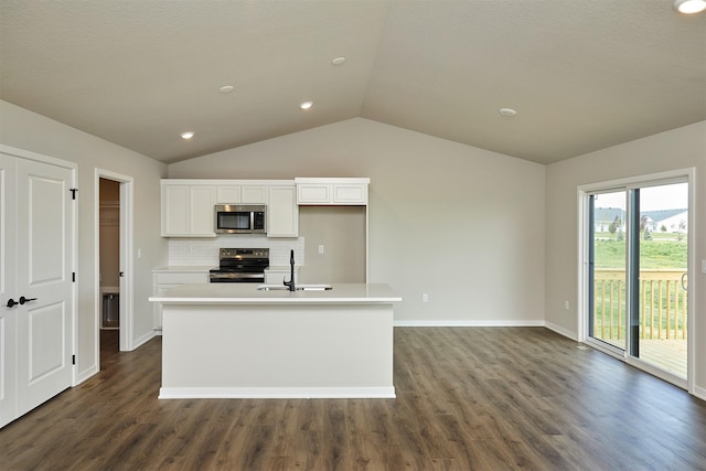 635 NW Compass Ave, Waukee, IA 50263 - kitchen with stainless steel appliances, lofted ceiling, white cabinetry, dark wood-style flooring, and an island with sink