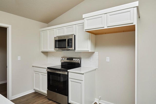 635 NW Compass Ave, Waukee, IA 50263 - kitchen featuring appliances with stainless steel finishes, backsplash, vaulted ceiling, light countertops, and white cabinets
