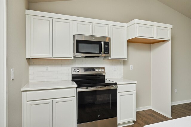 635 NW Compass Ave, Waukee, IA 50263 - kitchen featuring stainless steel appliances, lofted ceiling, dark wood finished floors, backsplash, and light countertops