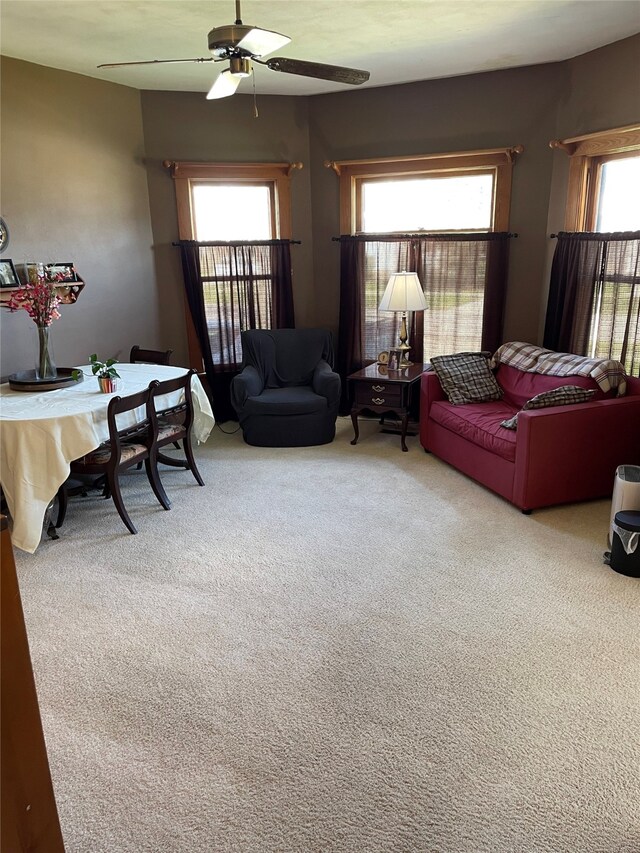 carpeted living area featuring ceiling fan