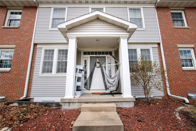 entrance to property featuring brick siding