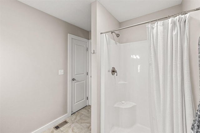 bathroom featuring baseboards, curtained shower, and visible vents
