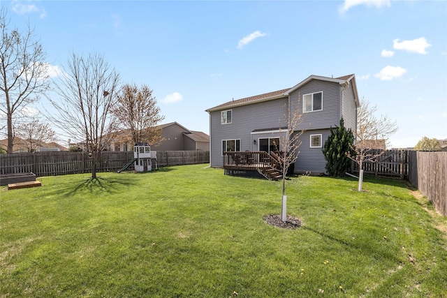 back of property featuring a fenced backyard, a deck, a yard, and a playground