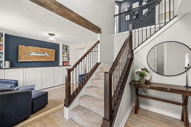 stairs featuring built in shelves, baseboards, and wood finished floors