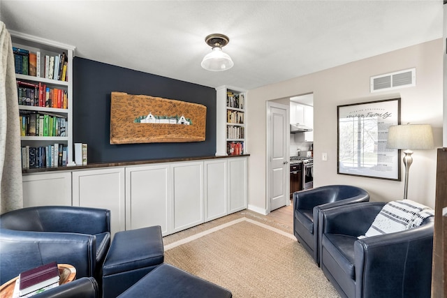 sitting room featuring light colored carpet and visible vents
