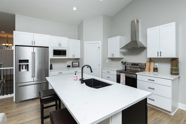 1040 W Trace Pl, Polk City, IA 50226 - kitchen with wall chimney range hood, a sink, light wood-type flooring, appliances with stainless steel finishes, and white cabinetry