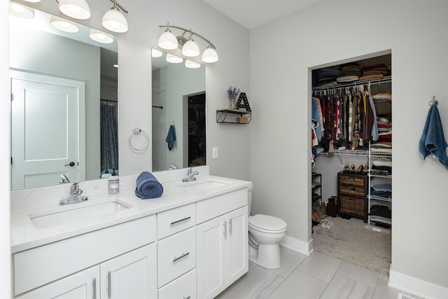 1040 W Trace Pl, Polk City, IA 50226 - bathroom with a walk in closet, toilet, a sink, and double vanity