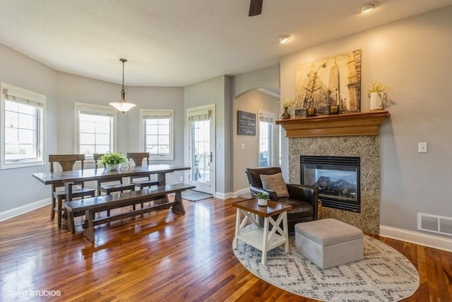 living area with wood finished floors, visible vents, and baseboards