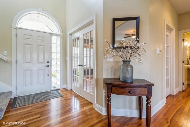 entrance foyer with baseboards, a ceiling fan, wood finished floors, and french doors