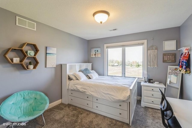 bedroom featuring a textured ceiling, dark colored carpet, visible vents, and baseboards