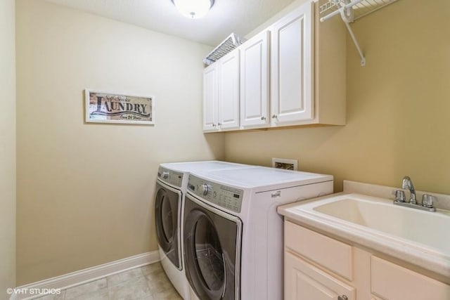 clothes washing area with washer and dryer, baseboards, cabinet space, and a sink