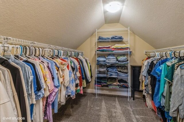 spacious closet featuring vaulted ceiling and carpet flooring