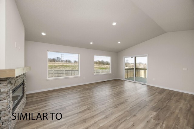 16514 Ironwood Ln, Urbandale, IA 50323 - unfurnished living room featuring lofted ceiling, a stone fireplace, wood finished floors, baseboards, and recessed lighting
