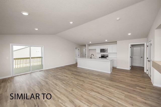 16514 Ironwood Ln, Urbandale, IA 50323 - unfurnished living room with vaulted ceiling, light wood-style floors, baseboards, recessed lighting, and a sink
