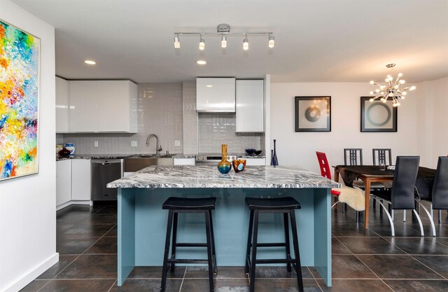 3663 Grand Ave Unit 905, Des Moines, IA 50312 - kitchen featuring a breakfast bar, white cabinetry, stainless steel appliances, and modern cabinets