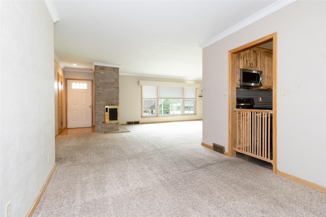 unfurnished living room with carpet, baseboards, ornamental molding, visible vents, and a large fireplace