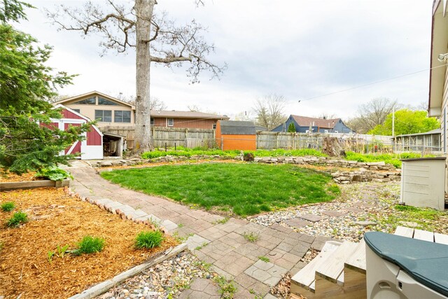 view of yard featuring an outbuilding, a storage shed, and a fenced backyard