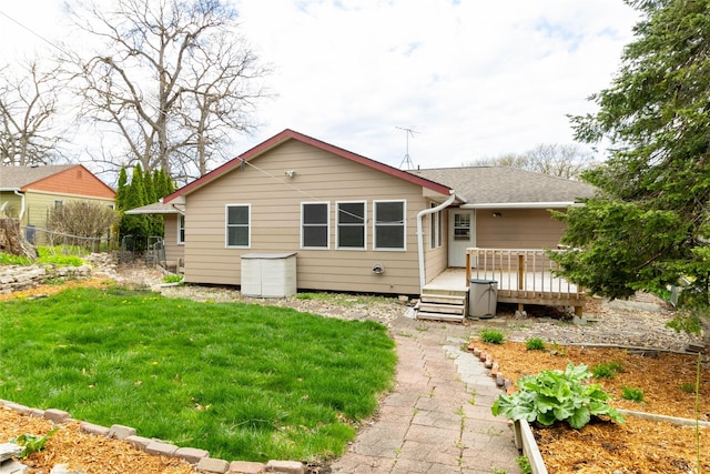 back of house featuring a yard, a wooden deck, roof with shingles, and fence