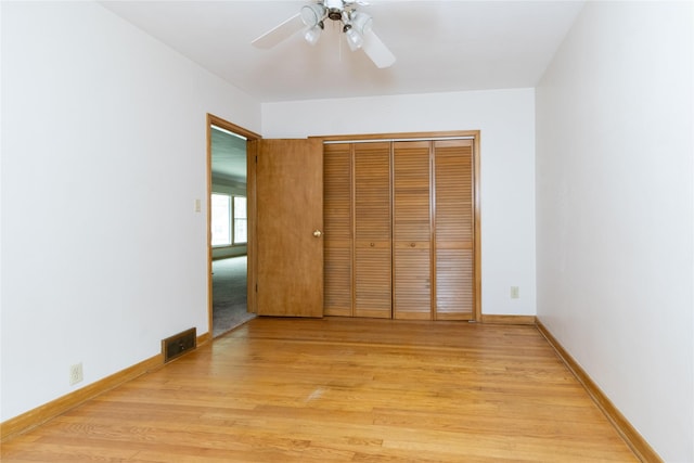 unfurnished bedroom with light wood-type flooring, baseboards, a closet, and visible vents