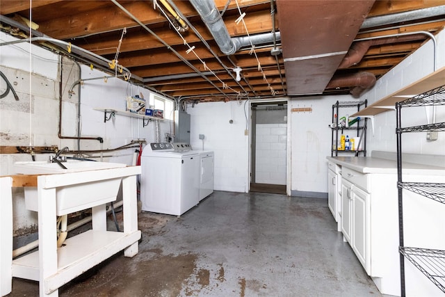 unfinished basement featuring concrete block wall and washer and clothes dryer