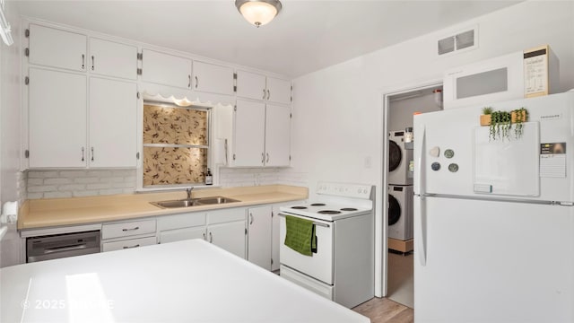 2318 56th St, Des Moines, IA 50310 - kitchen with a sink, visible vents, backsplash, white appliances, and stacked washer / drying machine