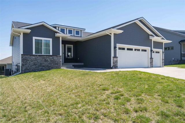 view of front of property featuring a front lawn, central air condition unit, stone siding, concrete driveway, and an attached garage