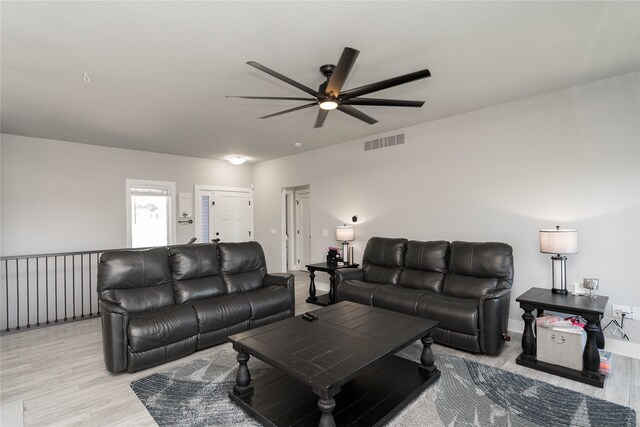 living room featuring ceiling fan, visible vents, and light wood-style flooring