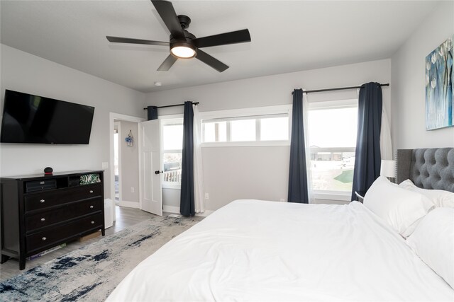 bedroom featuring light wood finished floors, a ceiling fan, and baseboards