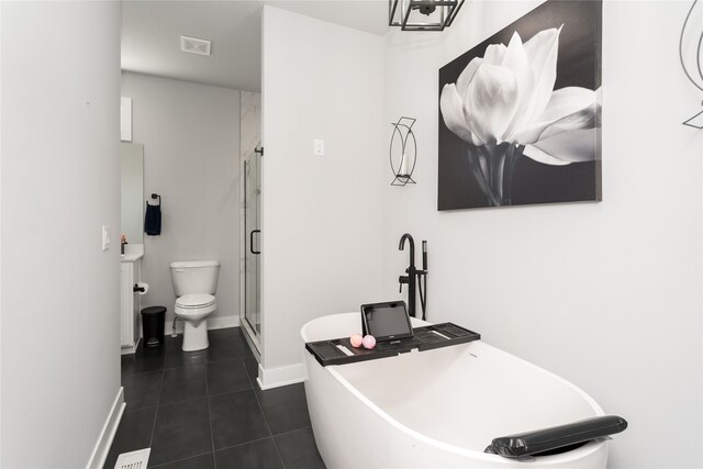 bathroom with a stall shower, toilet, baseboards, visible vents, and tile patterned flooring
