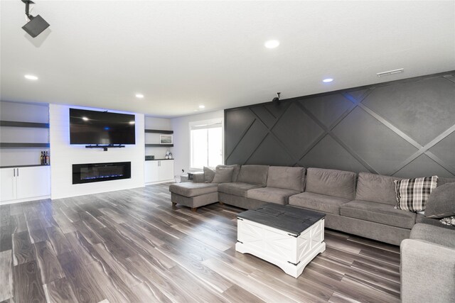 living area featuring a large fireplace, wood finished floors, and recessed lighting