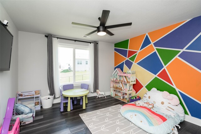 playroom featuring an accent wall, wood finished floors, baseboards, and ceiling fan