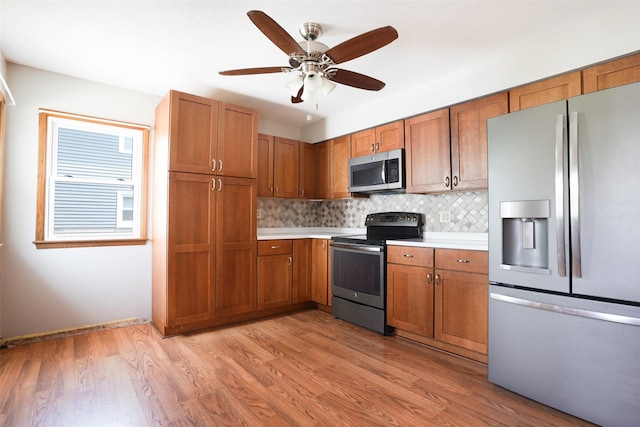 kitchen with stainless steel appliances, light countertops, backsplash, and brown cabinetry