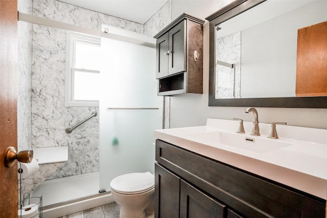 full bath featuring a stall shower, vanity, and toilet