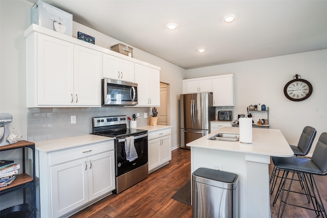 2802 SW Prairie Trail Pkwy, Ankeny, IA 50023 - kitchen with a sink, a breakfast bar area, dark wood finished floors, backsplash, and appliances with stainless steel finishes