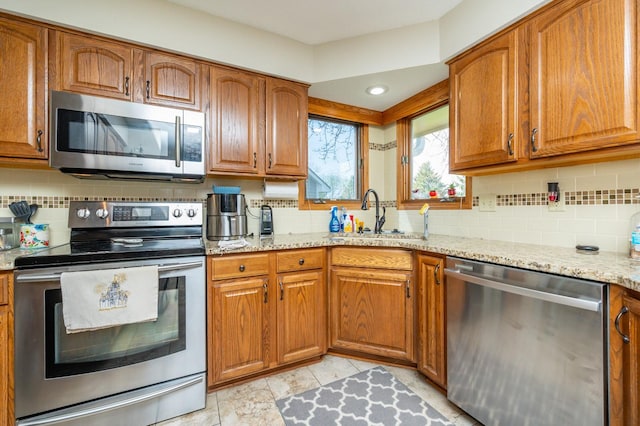 914 NE 9th St, Ankeny, IA 50021 - kitchen with brown cabinetry, appliances with stainless steel finishes, and a sink