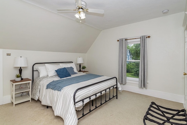bedroom featuring a ceiling fan, vaulted ceiling, light colored carpet, and baseboards