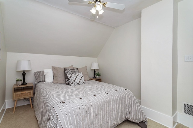 bedroom featuring baseboards, visible vents, light colored carpet, and vaulted ceiling