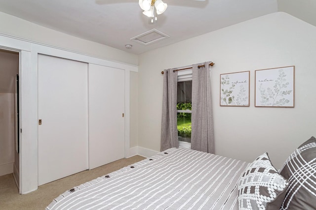 bedroom with attic access, a closet, a ceiling fan, and carpet floors